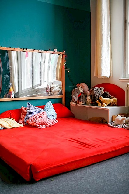 kuschelige rote Matratze mit bunten Kissen zum Entspannen