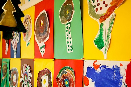 An der Wand aufgehängte Collagen aus bunten Papier und viel Farbe